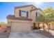 Two story home with an attached garage, desert landscaping and a covered porch seating area at 317 W Settlers Trl, Casa Grande, AZ 85122