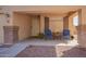 Covered front porch featuring brick columns and a seating area for two with desert landscaping at 317 W Settlers Trl, Casa Grande, AZ 85122