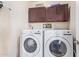 Laundry room featuring a white front load washer and dryer and upper storage cabinets at 317 W Settlers Trl, Casa Grande, AZ 85122
