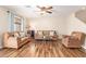 Inviting living room with neutral walls, ceiling fan, and comfortable brown sofa and armchair at 317 W Settlers Trl, Casa Grande, AZ 85122