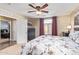 The main bedroom features a ceiling fan, upholstered bed frame with a floral comforter and large window at 317 W Settlers Trl, Casa Grande, AZ 85122