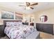 This is a main bedroom that features an upholstered bed frame, ceiling fan, and ensuite bath at 317 W Settlers Trl, Casa Grande, AZ 85122