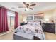 The main bedroom features a ceiling fan, upholstered bed frame with a floral comforter and large window at 317 W Settlers Trl, Casa Grande, AZ 85122