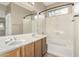 Bathroom with a double sink vanity, framed mirror, shower-tub combo, and a window at 39559 N Prairie Ln, Anthem, AZ 85086