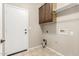 Functional laundry room with tile flooring, wooden cabinets, and convenient washer and dryer hookups at 39559 N Prairie Ln, Anthem, AZ 85086