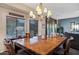 Elegant dining room featuring a large wood table, chandelier lighting, and window views, perfect for entertaining at 42072 W Dorsey Dr, Maricopa, AZ 85138