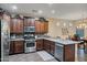 Gourmet kitchen features stainless steel appliances, decorative backsplash, ample cabinetry, and open layout to dining area at 42072 W Dorsey Dr, Maricopa, AZ 85138