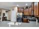 Well-equipped kitchen featuring dark wood cabinets, stainless steel appliances, breakfast bar and tiled backsplash at 42072 W Dorsey Dr, Maricopa, AZ 85138