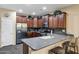 Well-equipped kitchen featuring dark wood cabinets, stainless steel appliances, breakfast bar and tiled backsplash at 42072 W Dorsey Dr, Maricopa, AZ 85138