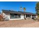 Single-story home featuring a two-car garage, desert landscaping, and mature palm trees on a sunny day at 520 E Jahns Pl, Casa Grande, AZ 85122