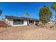 Single-story home featuring a two-car garage, desert landscaping, and mature palm trees on a sunny day at 520 E Jahns Pl, Casa Grande, AZ 85122