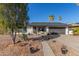 Charming single-story home featuring a two-car garage, desert landscaping, and mature palm trees on a sunny day at 520 E Jahns Pl, Casa Grande, AZ 85122