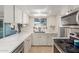 Well-lit kitchen with white cabinets, stainless steel appliances, and quartz countertops at 520 E Jahns Pl, Casa Grande, AZ 85122