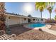 Inviting backyard pool with a covered patio, surrounded by palm trees and desert landscaping, perfect for relaxation and entertaining at 520 E Jahns Pl, Casa Grande, AZ 85122