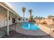 Backyard view of the in-ground pool, covered patio, and palm trees creating a private oasis at 520 E Jahns Pl, Casa Grande, AZ 85122