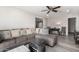 Comfortable living room with a large sectional sofa, ceiling fan, and gray wood-look flooring at 545 N 98Th St, Mesa, AZ 85207