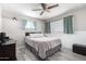 Bedroom with ceiling fan, two windows, and gray wood-look flooring at 545 N 98Th St, Mesa, AZ 85207