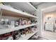Pantry area with ample shelving for storage, and gray wood-look flooring at 545 N 98Th St, Mesa, AZ 85207
