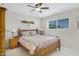 Bedroom with a wooden bed frame and a large window with a ceiling fan and neutral colored walls at 5525 E Thomas Rd # O8, Phoenix, AZ 85018