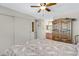 Bright bedroom featuring decorative armoire, ensuite bathroom, and a sliding closet with a ceiling fan at 5525 E Thomas Rd # O8, Phoenix, AZ 85018