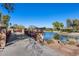 A community walking bridge spans over a peaceful pond, connecting residents to scenic views and walking paths at 5652 W Cinder Brook Way, Florence, AZ 85132