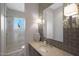 Bathroom featuring unique tile work, a decorative vase, a large mirror, and an enclosed glass shower at 5725 S Topaz Pl, Chandler, AZ 85249