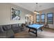 Game room featuring a billiards table, wood-look tile flooring, leather sofa, and a view of the bar area at 5725 S Topaz Pl, Chandler, AZ 85249