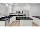 Contemporary kitchen featuring granite countertops, white cabinetry, and stainless steel appliances at 6392 W Pontiac Dr, Glendale, AZ 85308