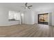 Bright living room with a ceiling fan, light hardwood floors, and sliding glass doors to the outside at 6392 W Pontiac Dr, Glendale, AZ 85308