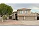 Charming two-story home showcasing a three car garage, mature trees, and desert landscaping for curb appeal at 6544 E Portia St, Mesa, AZ 85215