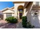 Exterior front door view featuring lush shrubbery and an arched entryway at 6544 E Portia St, Mesa, AZ 85215