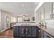 Well-designed kitchen with a stainless steel sink, brown granite counters, and views into the living room at 6544 E Portia St, Mesa, AZ 85215