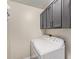 Functional laundry area with gray upper cabinets and a standard, white, side-by-side washer and dryer at 6544 E Portia St, Mesa, AZ 85215