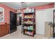 Bonus room featuring red paneling, carpet, and shelves with ample storage for equipment and supplies at 6544 E Portia St, Mesa, AZ 85215