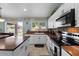 Bright kitchen features wood countertops, white cabinets, a stainless steel oven and a center island with tile flooring at 7346 N 82Nd Ave, Glendale, AZ 85303