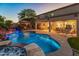 In-ground pool with spa, waterfall feature, and outdoor seating area under a pergola at 7381 W Paso Trl, Peoria, AZ 85383