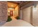 Front entryway with stone accents, a red front door, and a three car garage at 7381 W Paso Trl, Peoria, AZ 85383