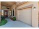 Inviting front exterior featuring a three-car garage, stone accents, and a covered porch at 7381 W Paso Trl, Peoria, AZ 85383