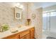 Bathroom with floral wallpaper, decorative mirror and cabinet storage at 7526 E Edgemont Ave, Scottsdale, AZ 85257