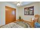 Charming bedroom featuring a ceiling fan, view to the outside, and wooden closet doors at 7526 E Edgemont Ave, Scottsdale, AZ 85257