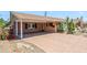 View of the home's covered carport and brick-paved driveway, framed by blooming bougainvillea at 7526 E Edgemont Ave, Scottsdale, AZ 85257