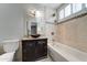 Well-lit bathroom featuring tiled walls, a single vanity and soaking tub at 7530 E Mariposa Dr, Scottsdale, AZ 85251