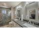 Modern bathroom featuring double sinks, gray countertops, tile shower, and decorative mirrors at 8305 E Lomita Ave, Mesa, AZ 85209