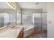 Bright bathroom featuring a soaking tub, glass block window and separate shower at 9102 E Pershing Ave, Scottsdale, AZ 85260