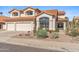 Charming two-story home with a well-manicured front yard, desert landscaping, and a three car garage at 9102 E Pershing Ave, Scottsdale, AZ 85260