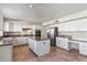 Well-lit kitchen featuring white cabinets, stainless steel appliances, and a granite-topped island at 9102 E Pershing Ave, Scottsdale, AZ 85260