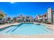 Community pool surrounded by patio furniture, trees, and residential buildings, with a clear blue body of water at 10115 E Mountain View Rd # 2112, Scottsdale, AZ 85258