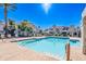 Bright, community pool with clear water, surrounded by lounge chairs, palm trees, and residential buildings, perfect for relaxation at 10115 E Mountain View Rd # 2112, Scottsdale, AZ 85258