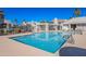 A clear blue pool with a metal handrail, set amidst palm trees, with residential buildings in the background at 10115 E Mountain View Rd # 2112, Scottsdale, AZ 85258