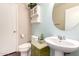 Half bathroom featuring a pedestal sink, decorative mirror, and storage cabinet at 1042 S Cheshire Ln, Gilbert, AZ 85296